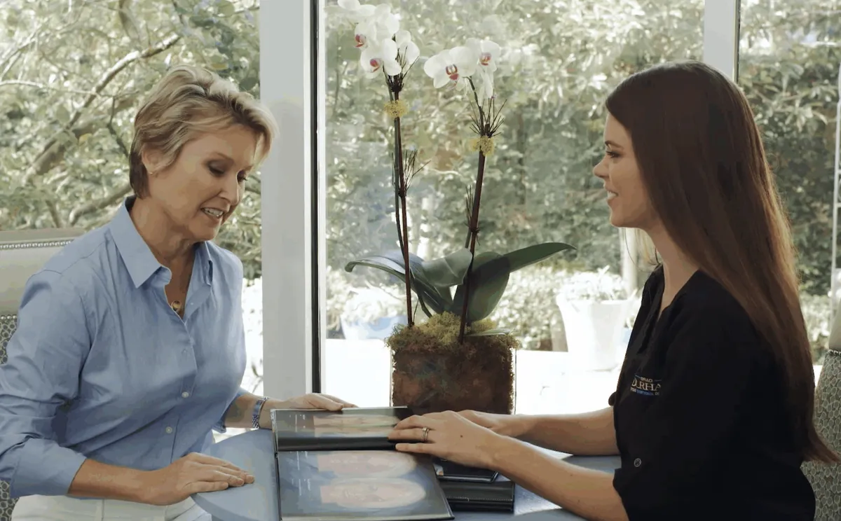 A patient reviewing her personalized treatment plan with the New Patient Coordinator by the garden window