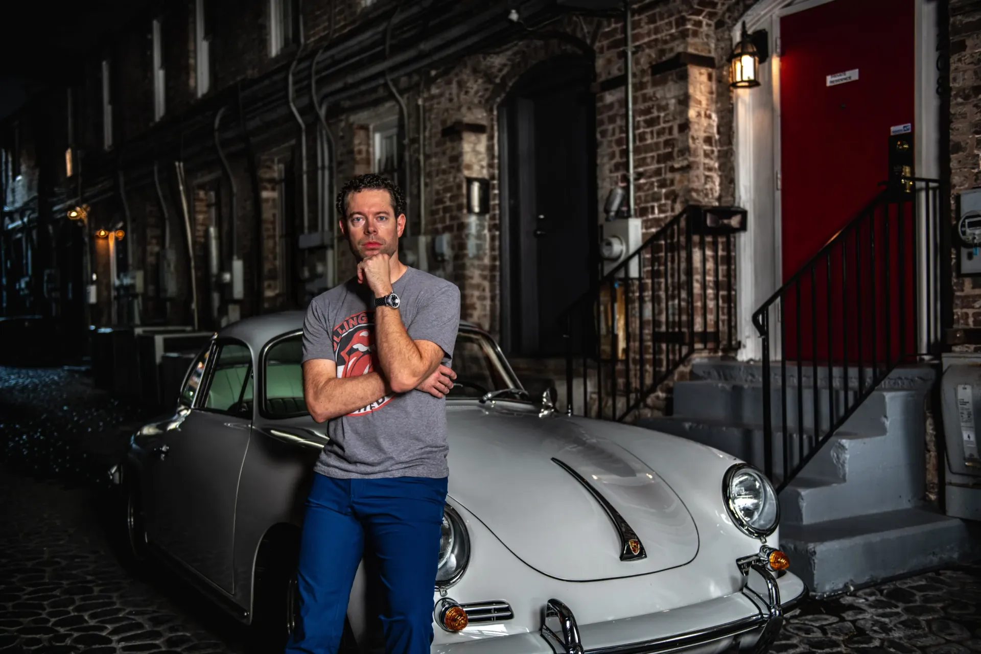 Dr. Ryan Reeves with a vintage Porsche on a cobblestone lane in Savannah's Historic District